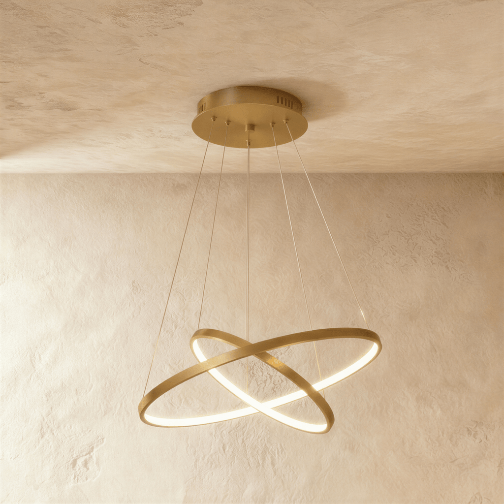 Clérachic's golden two-ring chandelier shows its rings overlapping in an X, lit warm above a textured room.