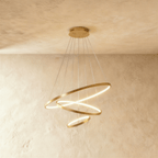 Three golden rings cascade in a staggered spiral in this Clérachic chandelier, each glowing warm from below.