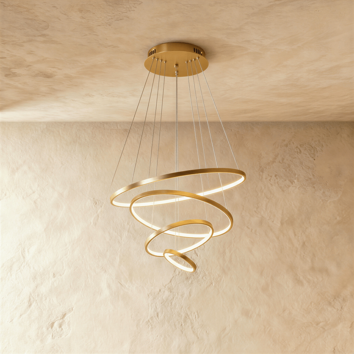 Four golden rings spiral downward in this Clérachic chandelier, each ring lit warm along its inner edge.