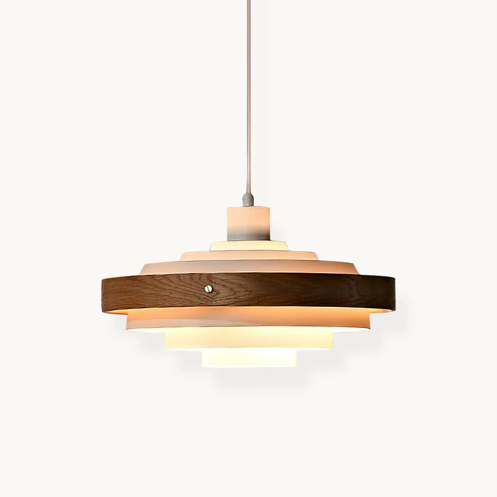 White and walnut stacked ring pendant from Clérachic, its tiers lit warm inside a walnut band, hung on a thin cord against white.