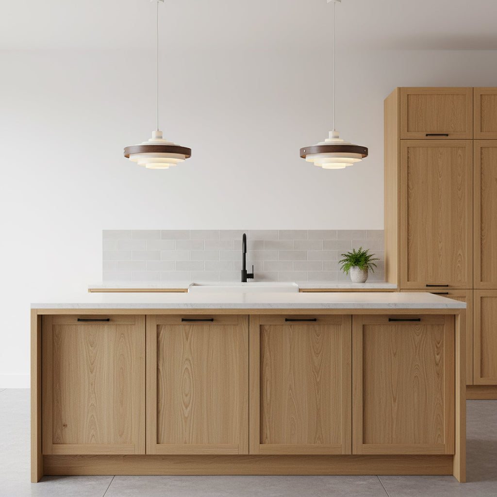 Two Clérachic stacked ring pendants hang over a light oak kitchen island with a white worktop and a black tap.