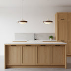 Two Clérachic stacked ring pendants hang over a light oak kitchen island with a white worktop and a black tap.