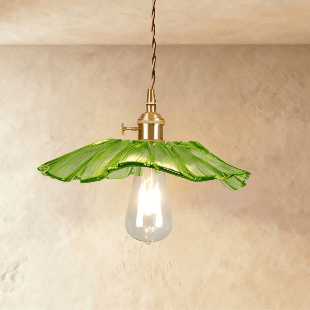 Clérachic shallow green glass pendant with a frilled rim on a brass holder, a long clear teardrop bulb glowing beneath it.