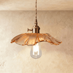 Clérachic shallow amber glass pendant with a ruffled copper-toned rim and a clear teardrop bulb, hung from a twisted cord.