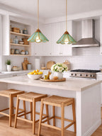 Two teal Clérachic pendants with scalloped shades over a white kitchen island, with wooden stools and a bowl of lemons.