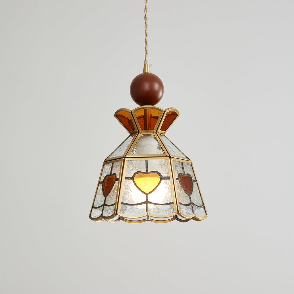 Lit Clérachic heart-panel pendant on grey, the amber hearts glowing at the front of its clear glass shade.