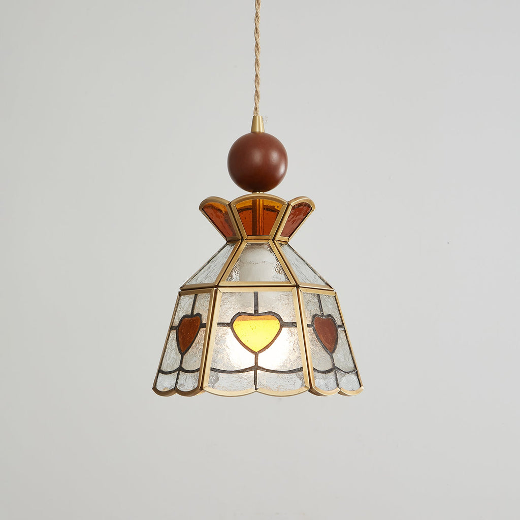 Clérachic heart-panel pendant switched off, showing its pale textured glass, amber hearts and brass frame on grey.