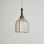 Unlit Clérachic pendant with a domed shade of textured clear glass in slim brass ribs and a turned wooden finial.