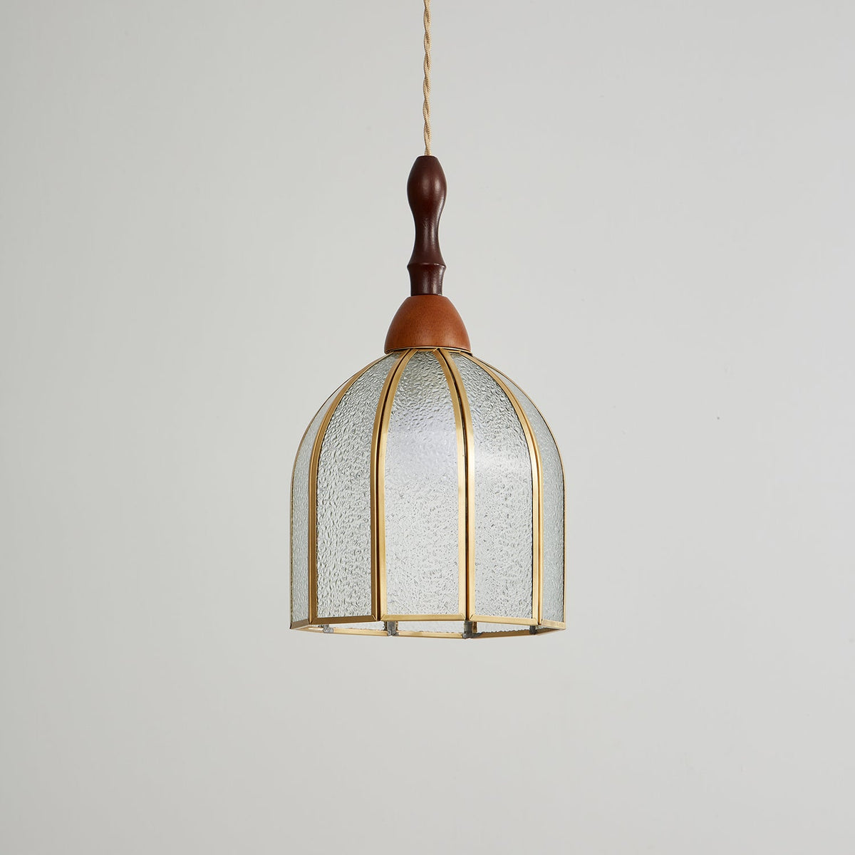 Unlit Clérachic pendant with a domed shade of textured clear glass in slim brass ribs and a turned wooden finial.