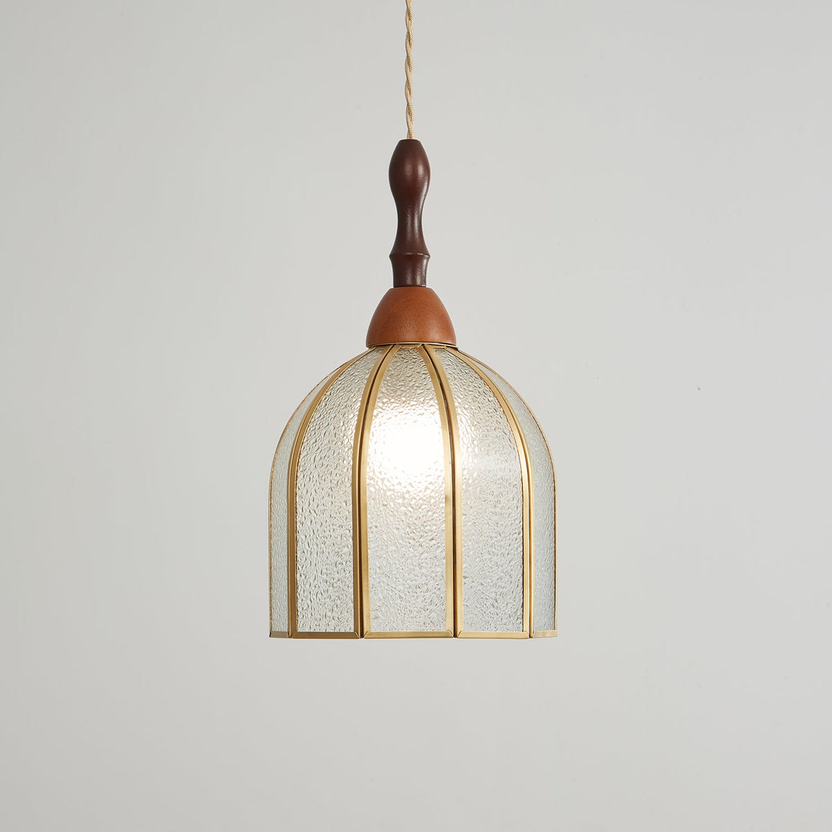 Larger view of the Clérachic domed pendant, its textured glass panels and brass ribs lit from within.