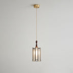 Small Clérachic frosted-panel pendant on a long twisted cord from a brass ceiling canopy, against a pale grey wall.