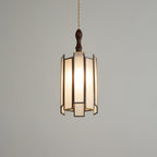 Clérachic frosted-panel pendant lit on a darker grey backdrop, with a slim finial and brass-edged panels.