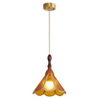 Amber Clérachic pendant with a flared scalloped shade on a long cord from a brass canopy, lit on a white backdrop.