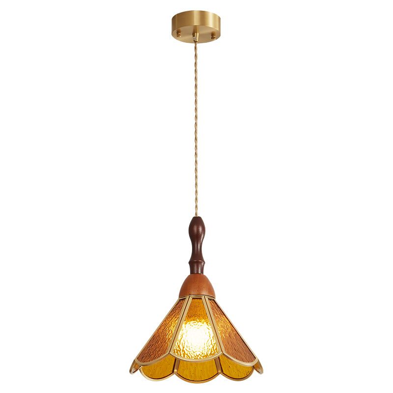Amber Clérachic pendant with a flared scalloped shade on a long cord from a brass canopy, lit on a white backdrop.