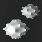 Black-and-white photo of two white Clérachic pendants of different sizes against a dark background.