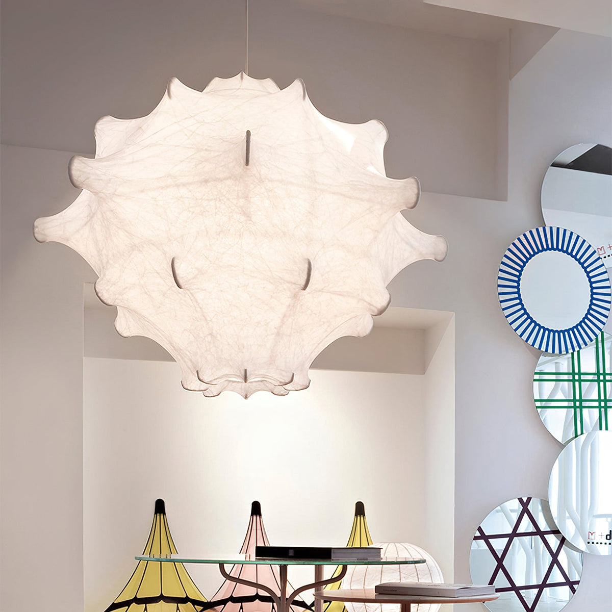 A large white Clérachic pendant seen from below, with its stitched seams visible, beside striped round mirrors.