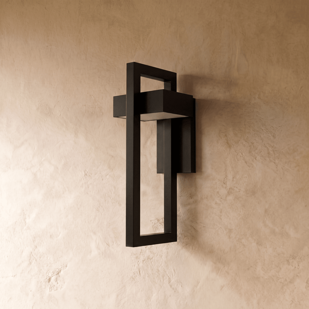 Side angle of the Clérachic steel wall light shows its layered rectangular frame casting a soft glow on plaster.
