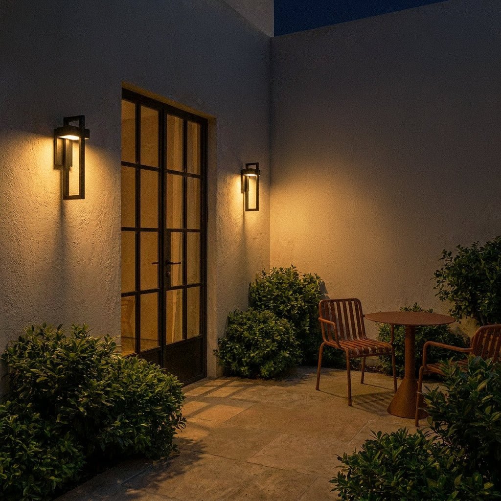 The same paneled entryway glows at night as both Clérachic steel wall lights light the door and boxwood planters.