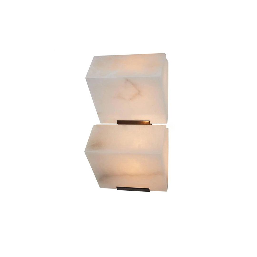 A two-block Clérachic alabaster wall light on a white backdrop, the lower block glowing warmer than the upper one.