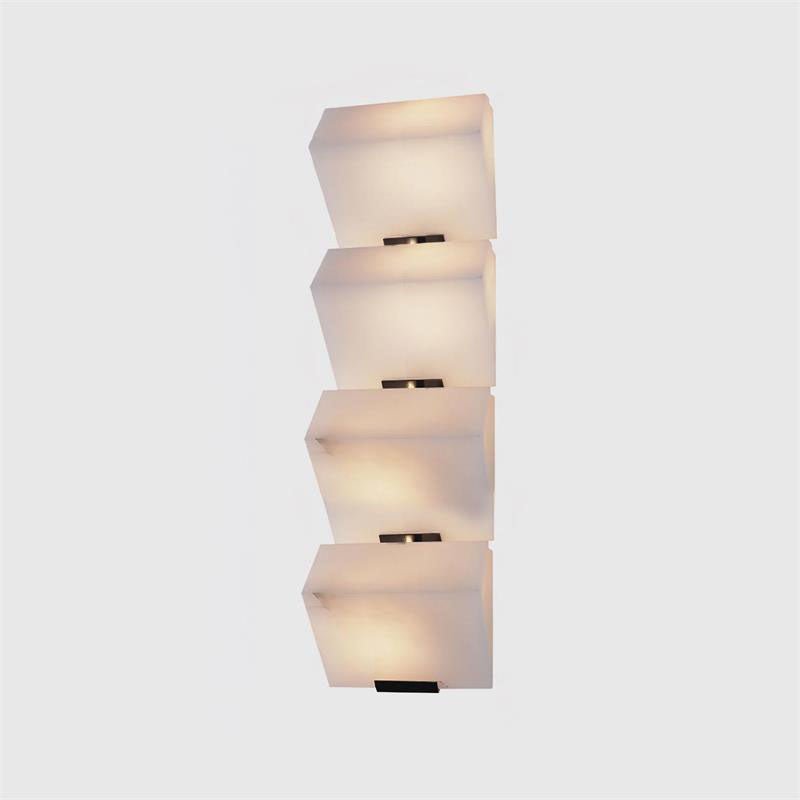 A four-block Clérachic alabaster wall light on a light grey backdrop, the stepped blocks lit softly above black plates.