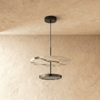 Clérachic pendant light switched off on the same warm cream plaster wall, its lower lens dark and its cord dropping from a round ceiling canopy.