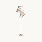 This Clérachic floor lamp on a plain backdrop, a slim gold stem branching into a tree of coloured agate slices above a round gold base.