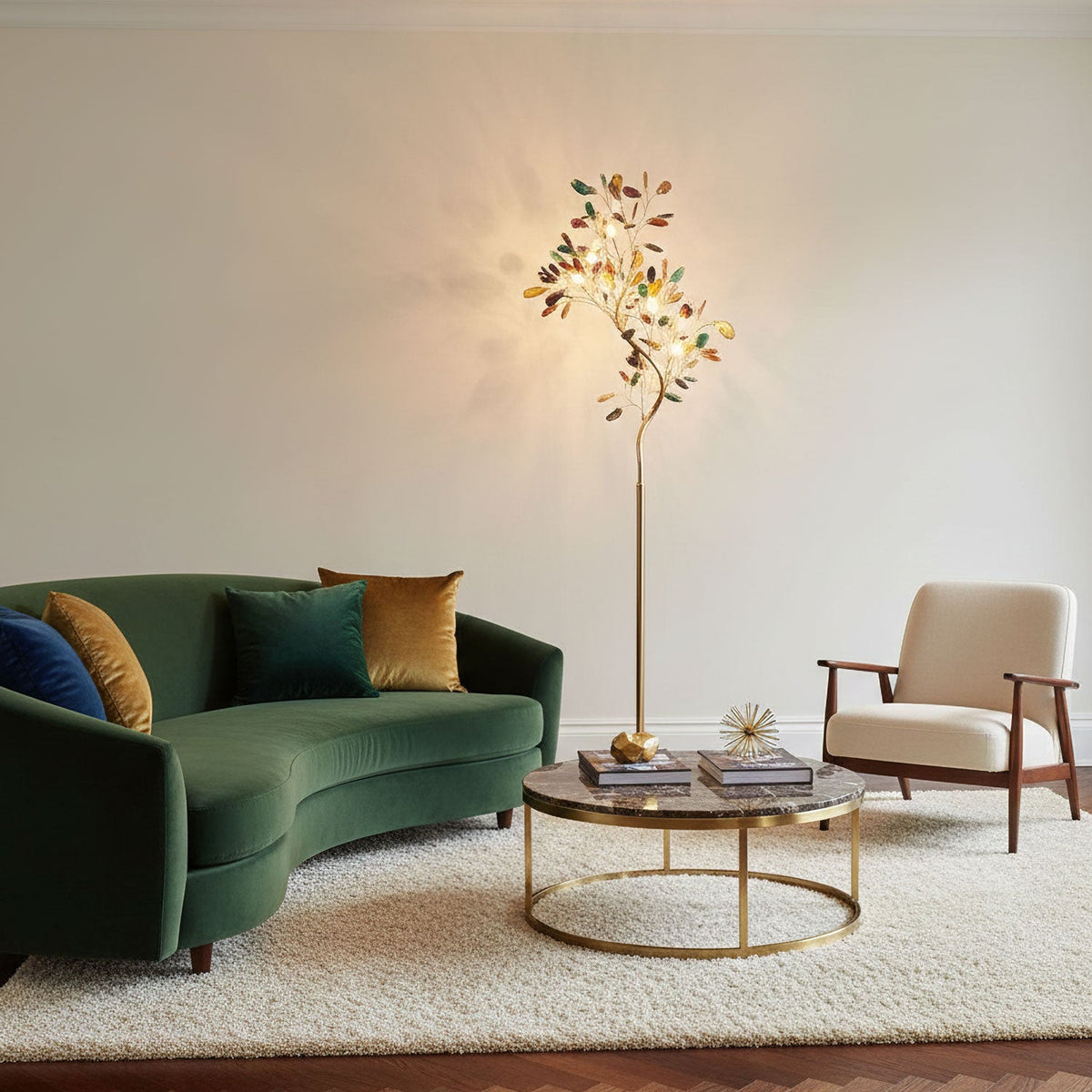 Lit Clérachic agate tree floor lamp beside a green velvet sofa, a round brass coffee table and a cream armchair.