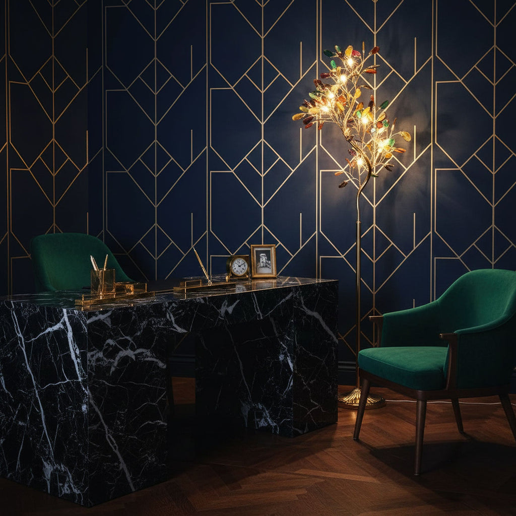 Lit Clérachic agate floor lamp against a navy wall with gold line patterning, near a black marble desk and green armchairs.