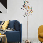 Clérachic agate floor lamp beside a blue sofa with a yellow cushion, against a pale wall with a monochrome print.