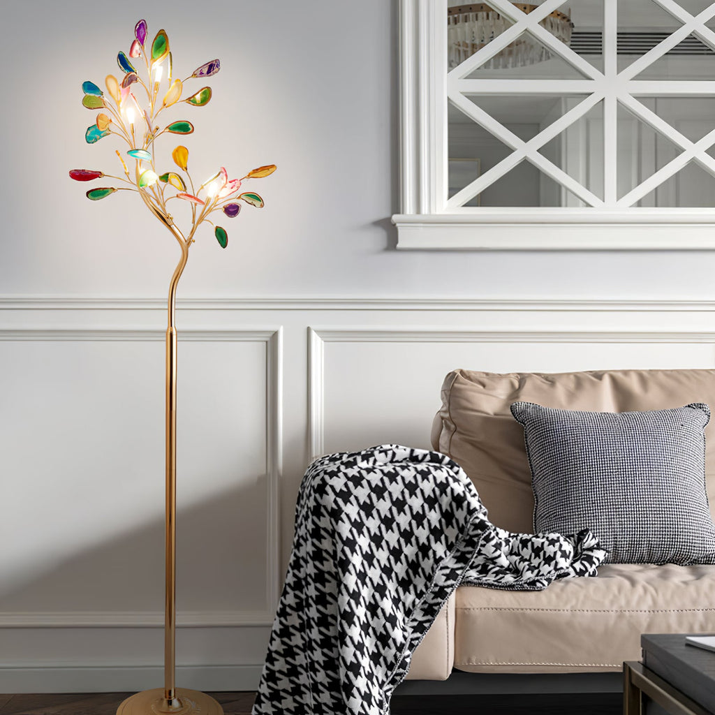 Lit Clérachic agate floor lamp beside a beige sofa with a houndstooth throw, in a white room with panelled walls.
