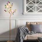Lit Clérachic agate floor lamp beside a beige sofa with a houndstooth throw, in a white room with panelled walls.