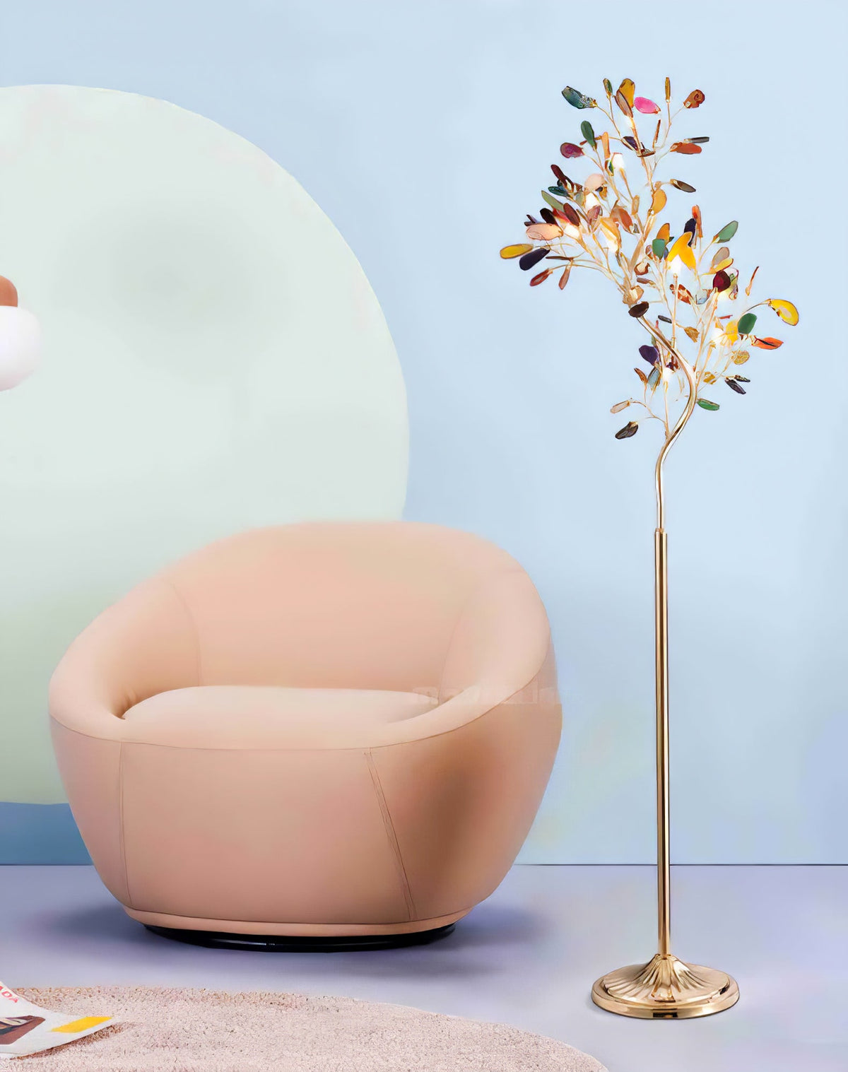 Clérachic agate floor lamp beside a peach round armchair, in front of a pale blue wall with a soft arch shape.