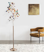 Clérachic agate floor lamp beside a mustard velvet armchair, on a rug, against a white wall with an abstract painting.