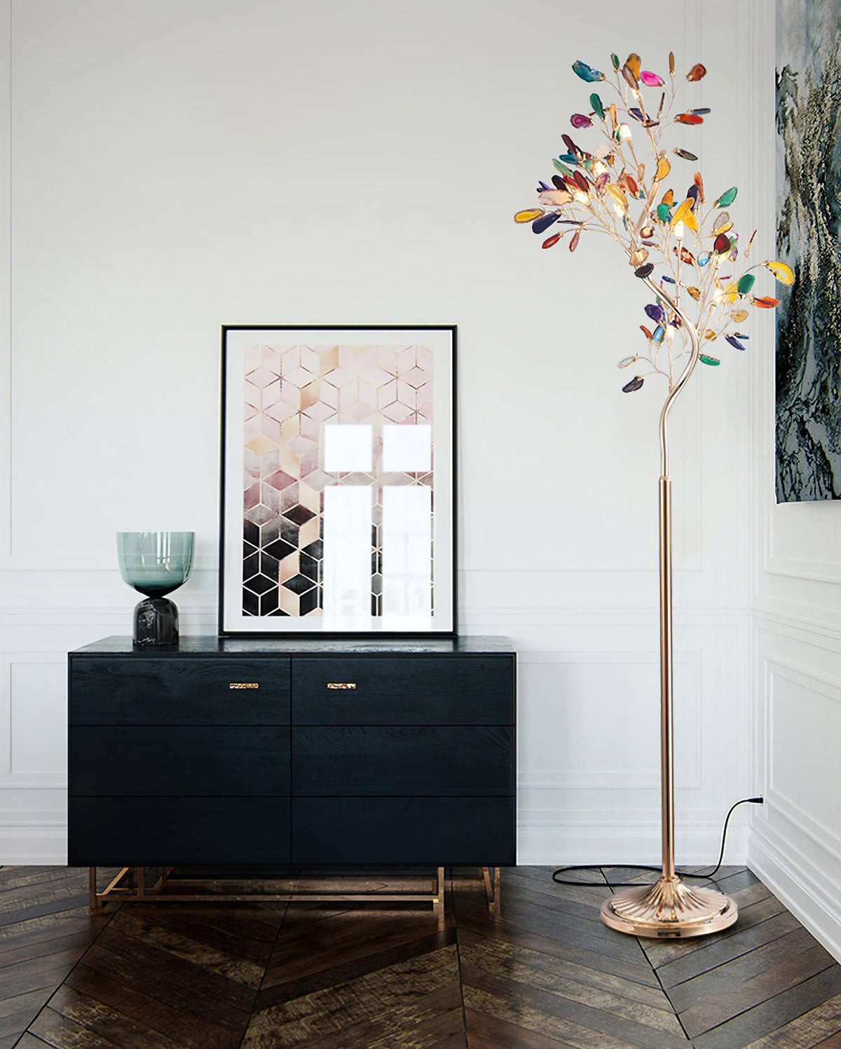 Clérachic agate floor lamp beside a black sideboard and a framed geometric print, on a dark wood herringbone floor.