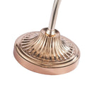 Close view of the fluted rose-gold base and curved stem of this Clérachic floor lamp, on a white background.