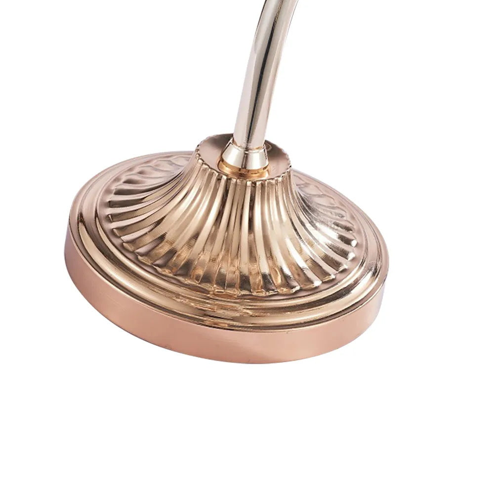 Close view of the fluted rose-gold base and curved stem of this Clérachic floor lamp, on a white background.
