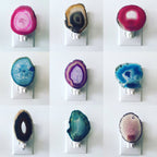 Small agate night lights in many colours, each fixed over a plug-in socket, shown as a reference for the stone used in this Clérachic floor lamp.