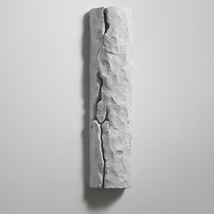 Unlit pale grey wall light with a deep dark crack down its centre, on a light grey wall, from Clérachic.