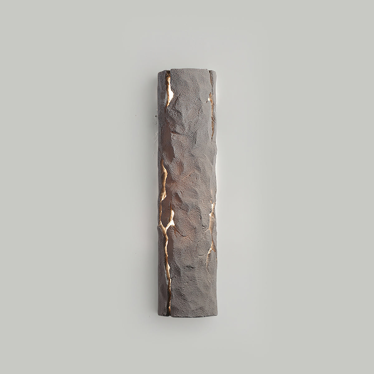 Taupe-grey stone-look wall light lit softly through cracks on a pale grey wall, from Clérachic.
