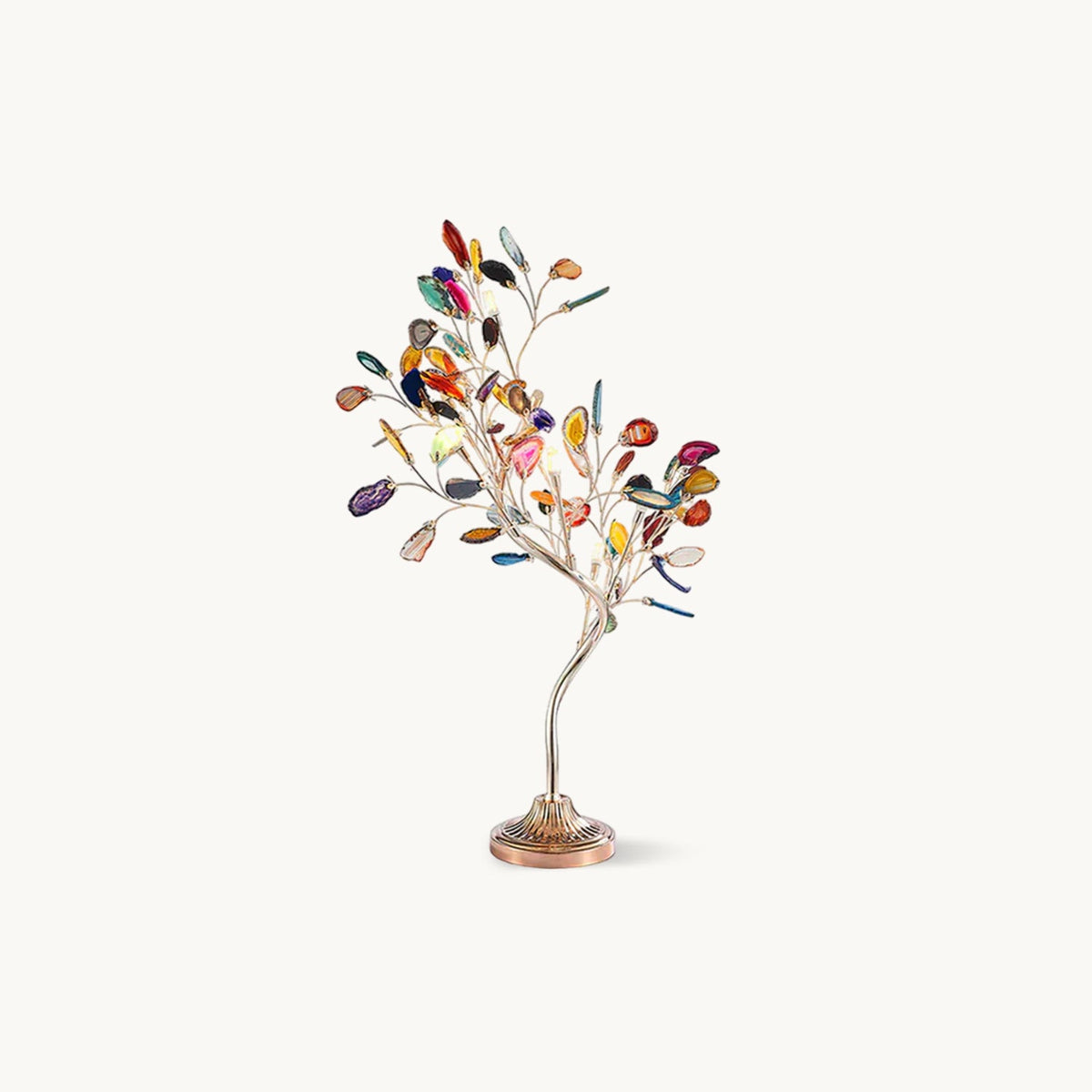 A Clérachic table lamp shaped like a small tree, with multicoloured agate slices for leaves on a bronze-gold stem and round fluted base, on white.