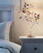 Agate slices in many colours cover the branches of this Clérachic table lamp, standing on a pale blue bedside cabinet.