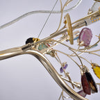 Close view of the gold-toned branches, bulb holders and a hanging agate slice on this Clérachic table lamp.