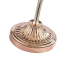 Close view of the fluted, rose-gold round base and the curving stem of this Clérachic table lamp.