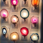 Loose agate slices with bright centres glow on a wall of plug-in night lights, shown beside this Clérachic lamp's gallery.