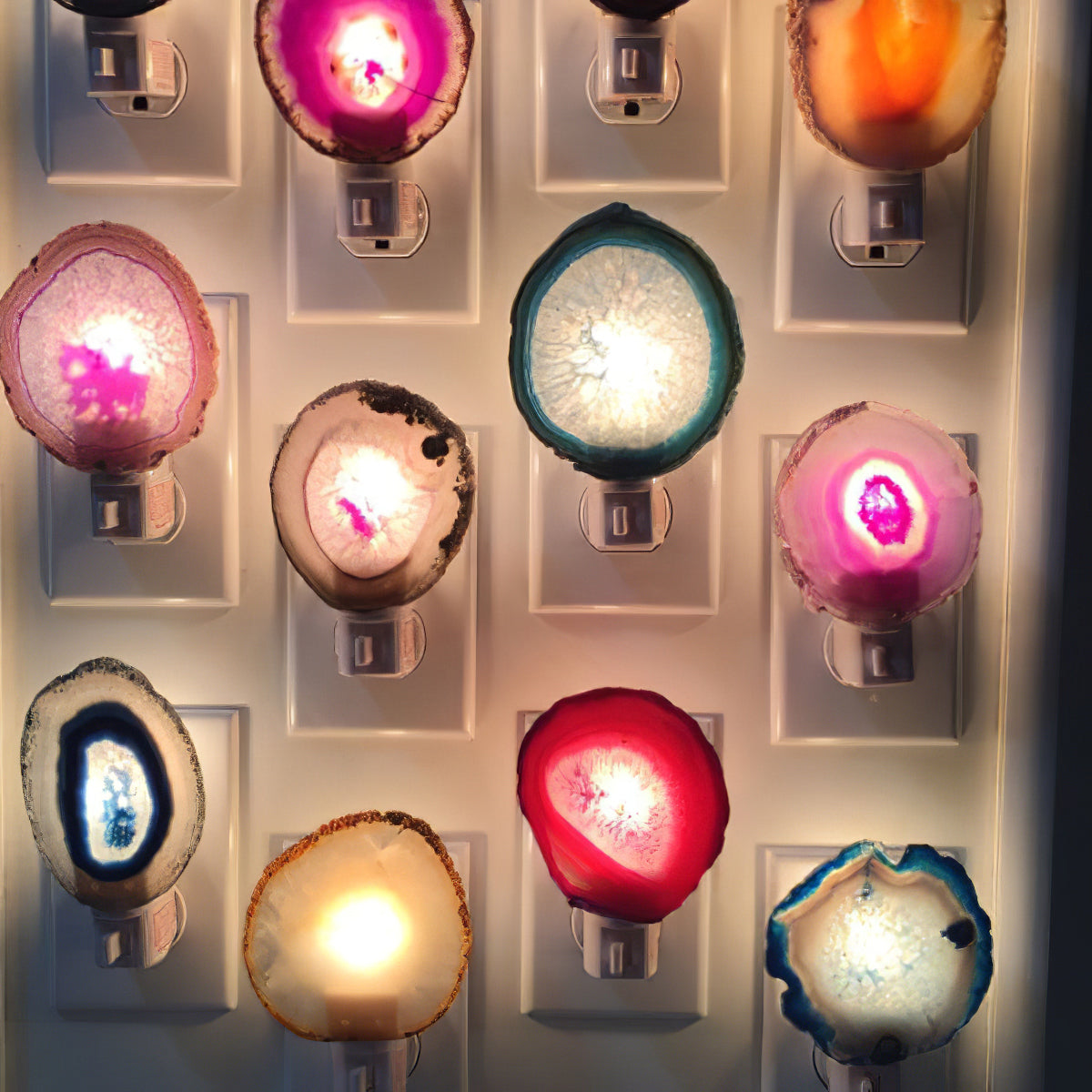 Loose agate slices with bright centres glow on a wall of plug-in night lights, shown beside this Clérachic lamp's gallery.