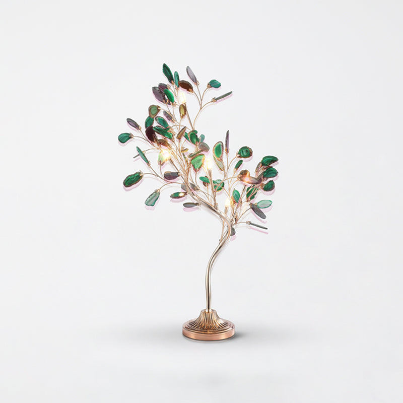 This Clérachic table lamp carries green agate leaves, with warm bulbs showing among the branches, against pale grey.