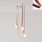 The Strap-Hung Glass Globe Pendant Light in red canvas, Clérachic's three-head version with globes staggered at different drop heights beside a fabric swatch.