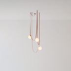 Compact studio view of the Clérachic Strap-Hung Glass Globe Pendant Light, three red canvas straps carrying globes to different depths against a plain backdrop.