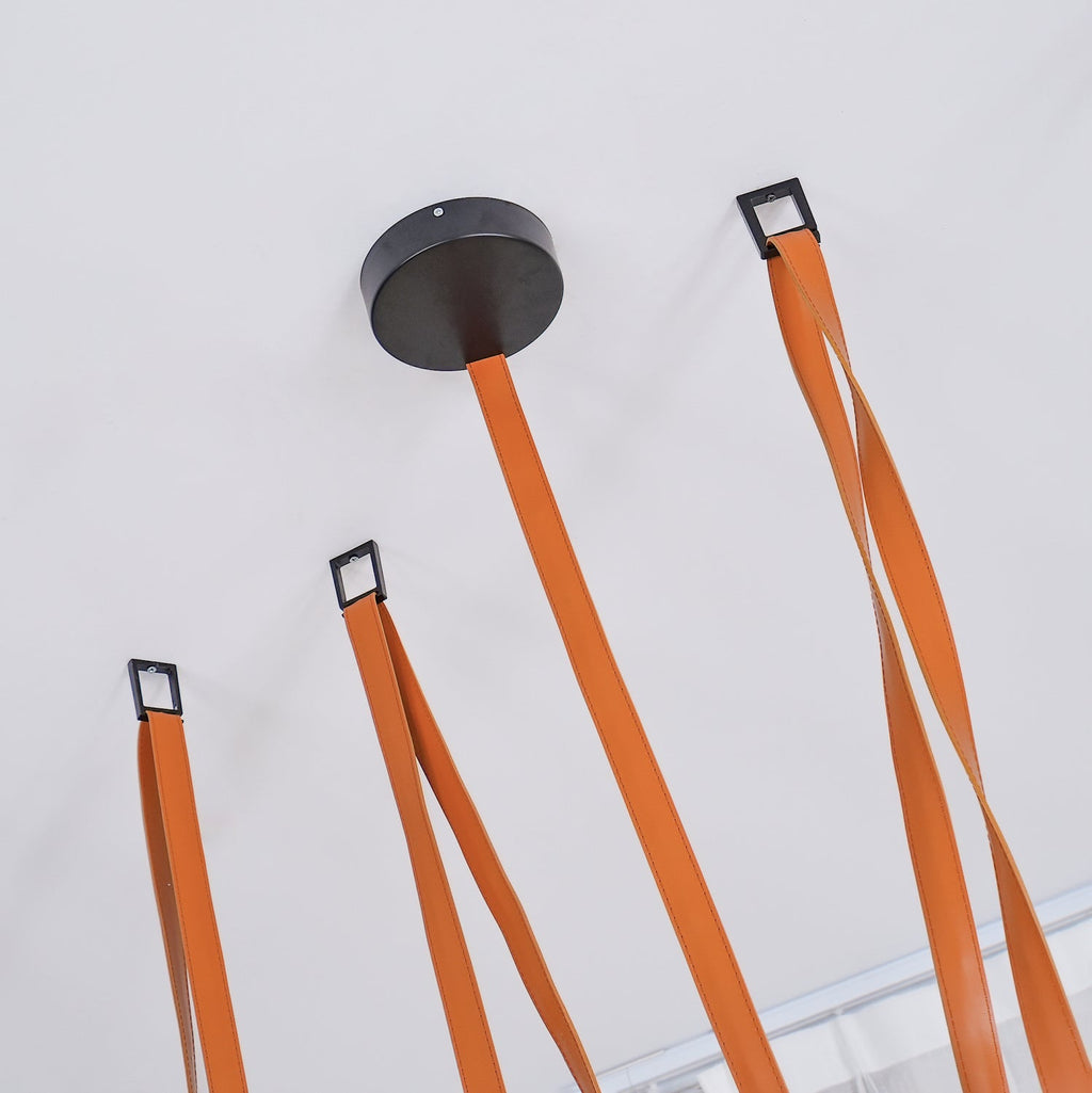 Ceiling mount detail of the Clérachic Strap-Hung Glass Globe Pendant Light, showing the round canopy and individual black hooks that carry each leather strap.