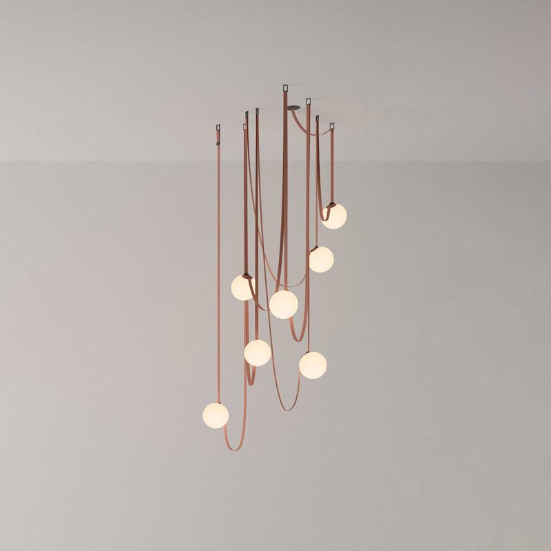 Studio view of a larger Clérachic Strap-Hung Glass Globe Pendant Light cluster, its rust canvas straps carrying globes to varied drop heights.